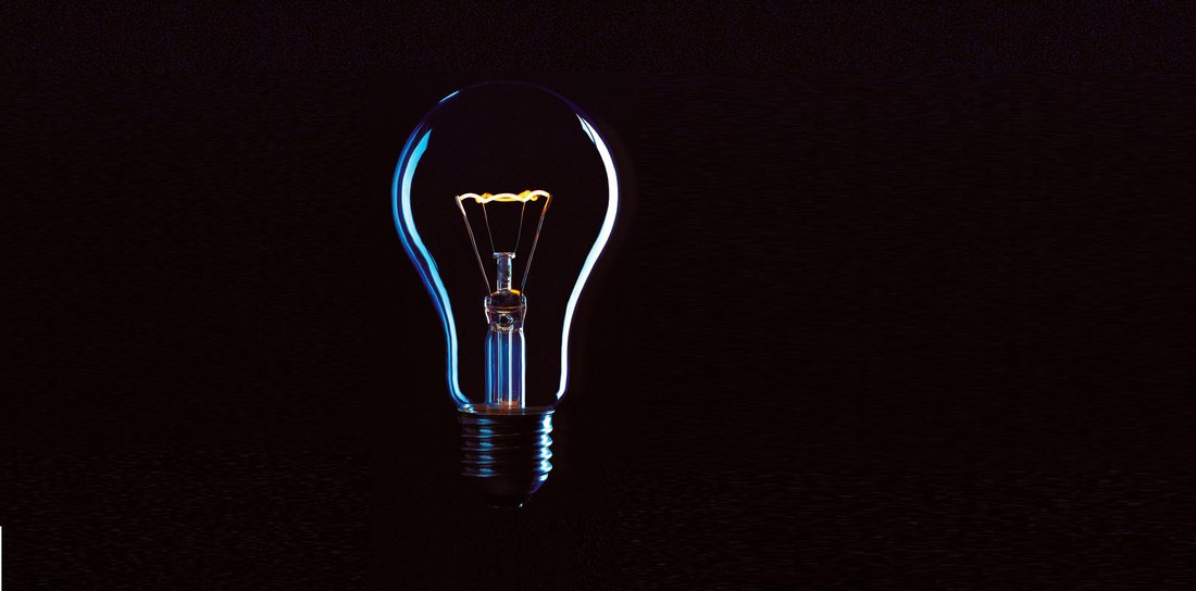 A glowing lightbulb against a dark background